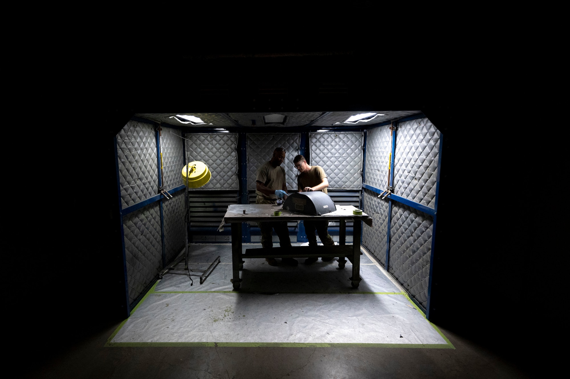 U.S. Air Force Staff Sgts. Devon Gourdine, left, and Braden Gibson, 49th Equipment Maintenance Squadron aircraft structural maintenance craftsmen, paint a piece of an F-16 Viper in a corrosion room at Holloman Air Force Base, New Mexico, Oct. 2, 2023. The Airmen of the 49th EMS sheet metals shop utilize a variety of methods to ensure that the 49th Wing’s F-16 Vipers are provided with the proper materials and parts to keep the structural integrity of the jet intact. (U.S. Air Force photo by Airman 1st Class Isaiah Pedrazzini)