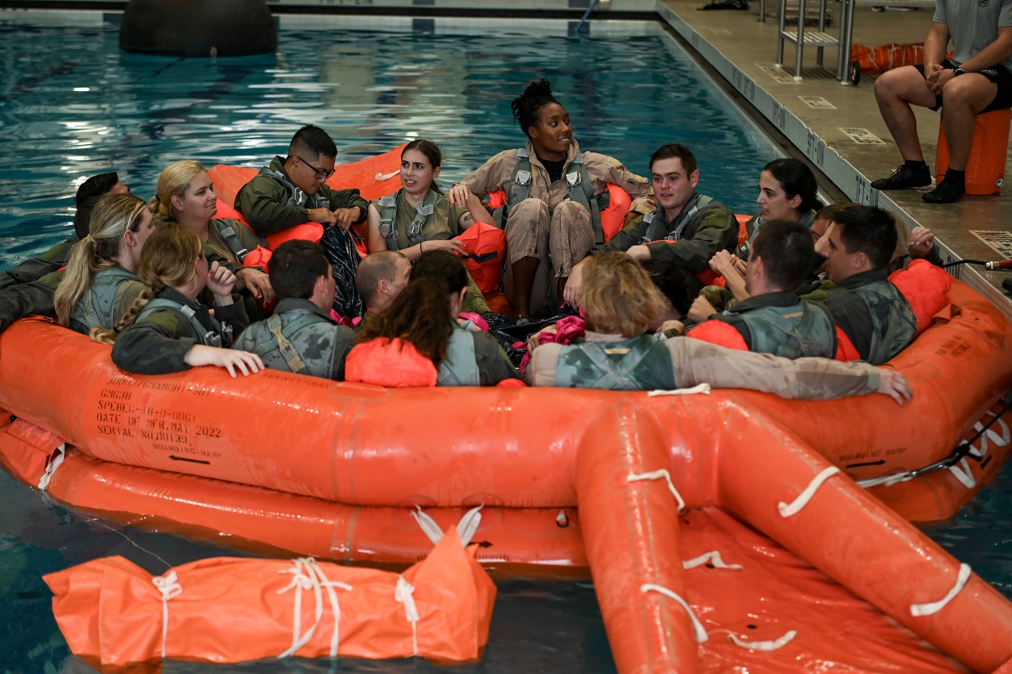 Team USA Swimmers sit in raft with SERE students