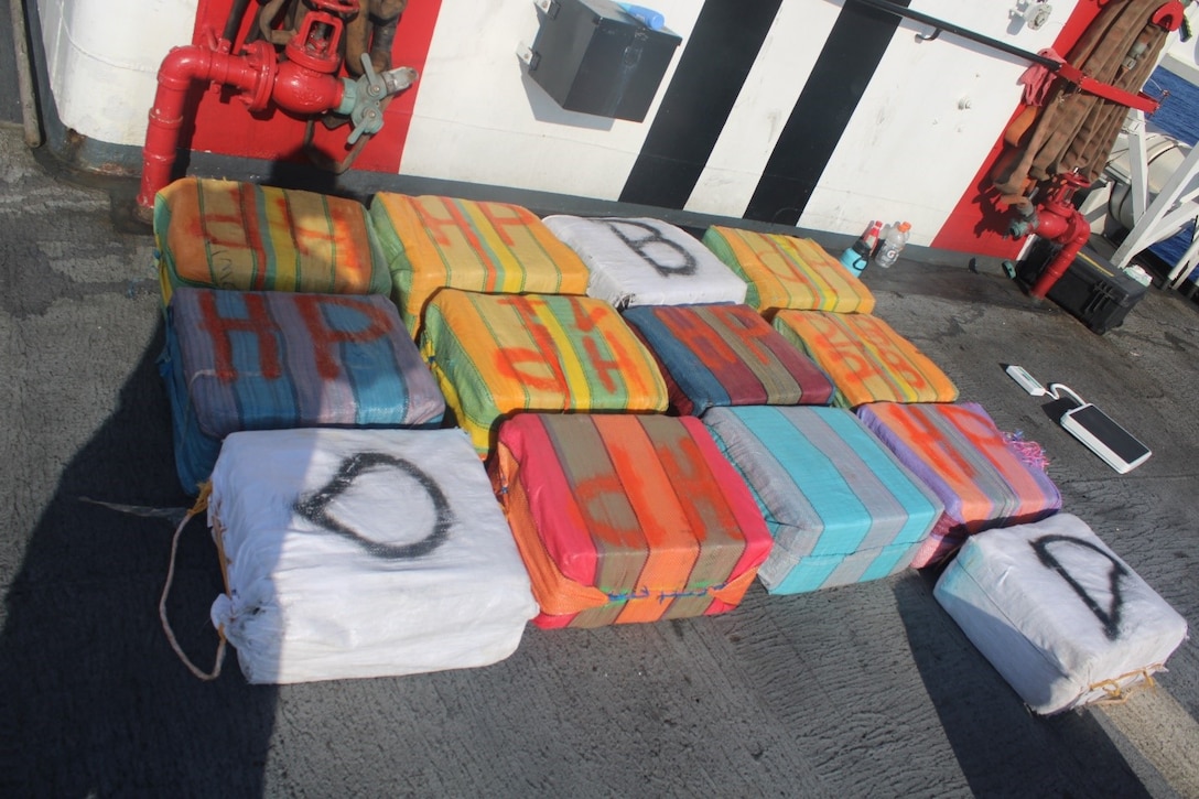 Bags of interdicted cocaine lay on the deck of a Coast Guard cutter