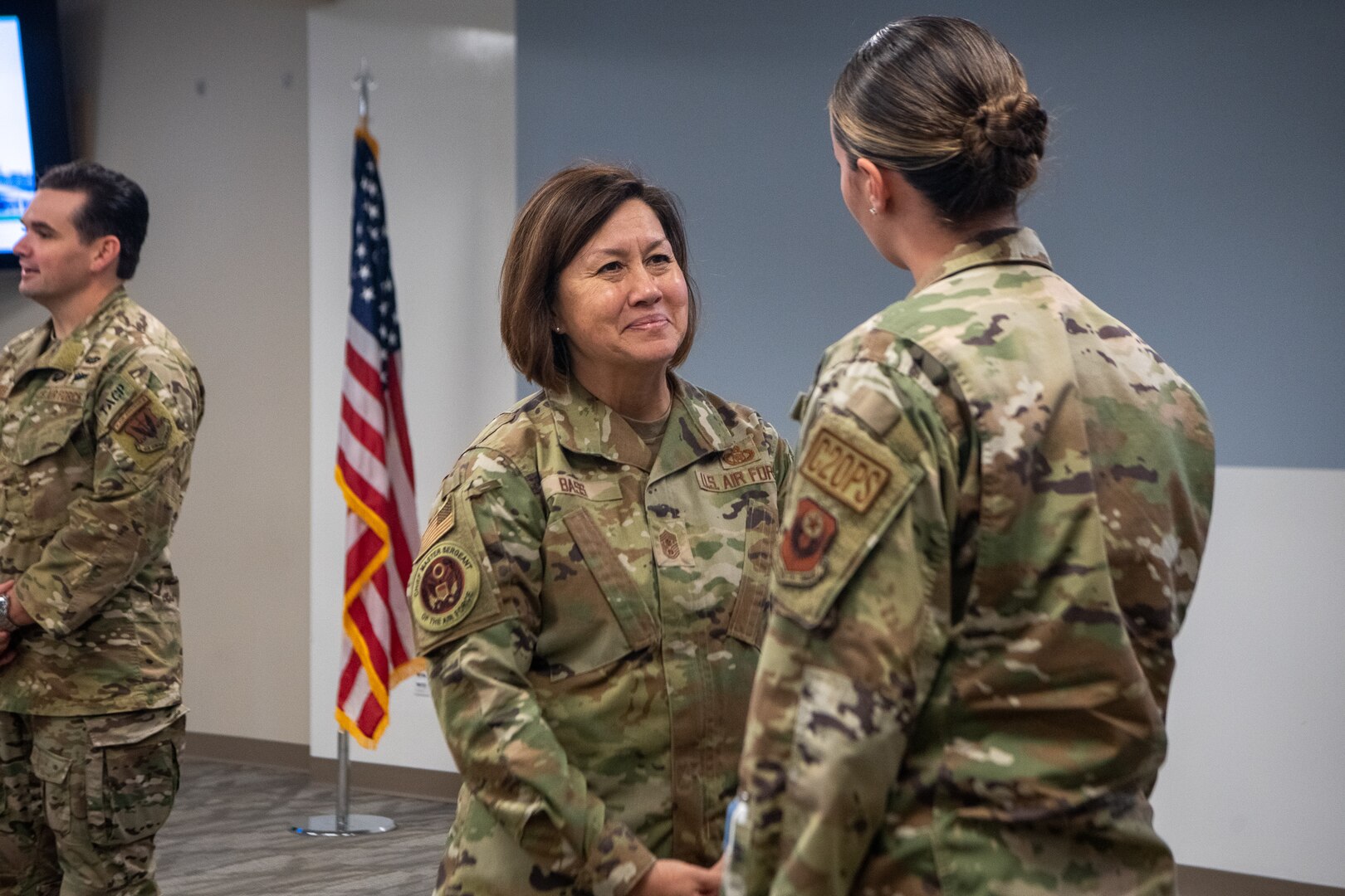 woman smiles as another woman speaks