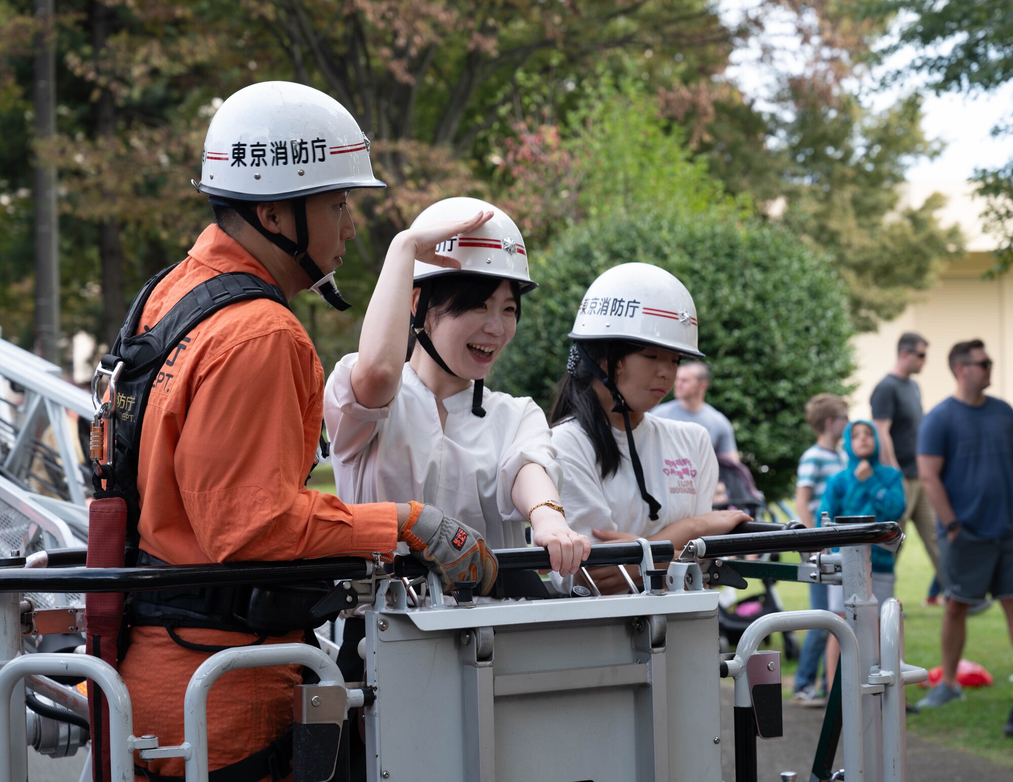 Firefighters from the Tokyo Fire Department lift attendees in a fire truck.