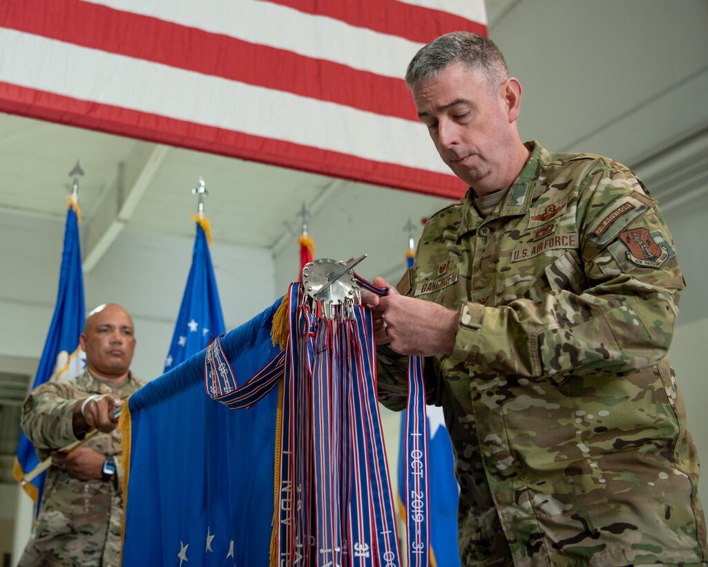 Col. Bruce Bancroft, 123rd Airlift Wing commander, pins a streamer to the unit colors during a ceremony at the Kentucky Air National Guard Base in Louisville, Ky., Oct. 14, 2023. The streamer signifies the unit’s selection for its 20th Air Force Outstanding Unit Award, continuing its legacy as one of the most decorated organizations in U.S. Air Force history. (U.S. Air National Guard photo by Tech. Sgt. Joshua Horton)