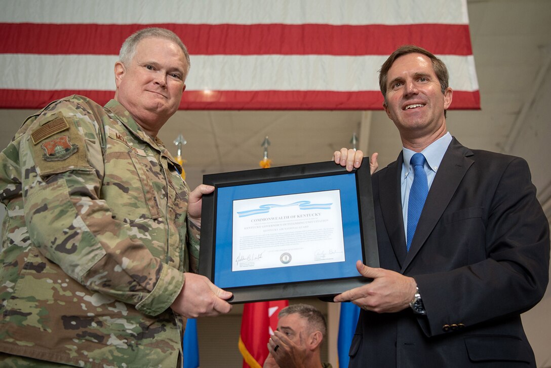 Kentucky Gov. Andy Beshear, right, presents the Kentucky Governor’s Outstanding Unit award to Brig Gen. David Mounkes, Kentucky’s assistant adjutant general for Air, during a ceremony at the Kentucky Air National Guard Base in Louisville, Ky., Oct. 14, 2023. The ceremony, which highlighted the unit’s accomplishments over the last four years, concluded with the presentation of the wing’s 20th Air Force Outstanding Unit Award. (U.S. Air National Guard photo by Tech. Sgt. Joshua Horton)