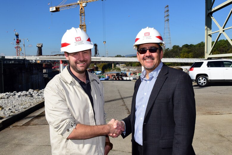Secretary of the Army for Civil Works Michael L. Connors (Right) presents a challenge coin recognizing excellence to Civil Engineer Ryan Cleary for his work on the Chickamauga Lock Replacement Project while touring the project Oct. 12, 2023, on the Tennessee River in Chattanooga, Tennessee. (USACE Photo by Lee Roberts)
