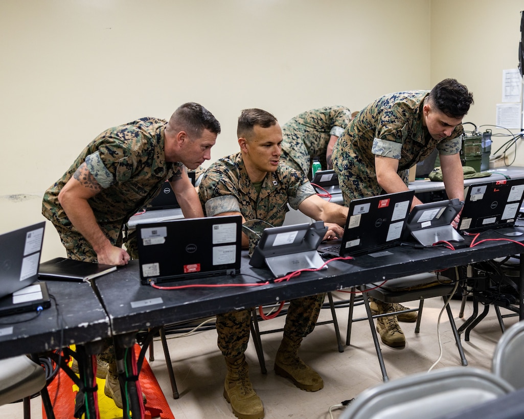 U.S. Marine Master Sgt. Daniel Thompson, left, a joint fires integrator, Capt. Eaton, an artillery officer, center, and Sgt. Samuel Berkheimer, right, a fire support Marine, with Task Force 76/3, set up Advanced Field Artillery Tactical Data Systems and a Joint Automated Deep Operation Coordination System during Integrated Littoral Warfare Center (ILWC) dislocation training at the Ie Shima Training Facility on Iejima, Okinawa, Japan Sept. 11, 2023. Task Force 76/3 is training at Ie Shima Training Facility to demonstrate proficiency in establishing command and control, communications, computers, and intelligence architecture in support of operations and coordination with Bravo Co., 7th Communication Battalion, III Marine Expeditionary Force Information Group. (U.S. Marine Corps photo by Gunnery Sgt. Andrew Ochoa)