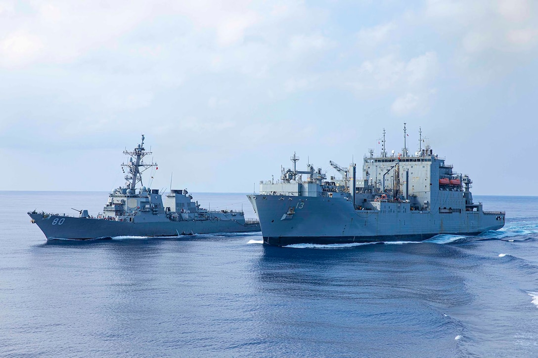Two ships sail side by side during a replenishment at sea.