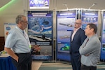 Andrew Nagelhout (from right), deputy head of the Naval Undersea Warfare Center Division Newport Contracts Department, and Chris Kenney, head of Procurement Division 1, Code 022, speak with a visitor at Defense Innovation Days hosted by the Southeastern New England Defense Industry Alliance at the Marriott in Newport, Rhode Island, on Aug. 29, 2023. Contracting professionals connected more than two dozen exhibitors with scientists and engineers at the warfare center during the event.