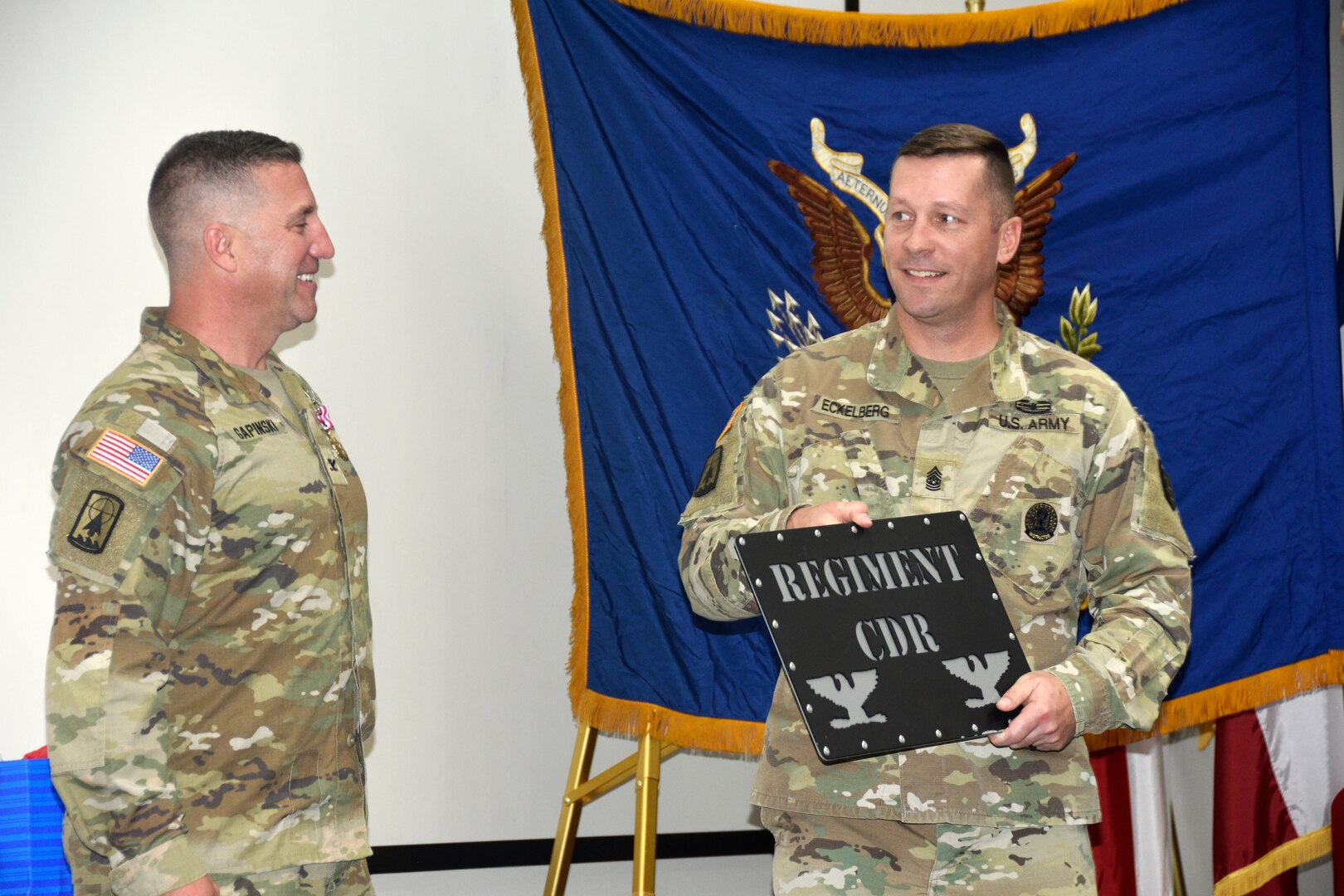 Command Sgt. Maj. Hayden Eckelberg, commandant for the Wisconsin Army National Guard’s 426th Regiment, presents outgoing commander Col. Paul Gapinski with a reserved parking sign during a formal change of command ceremony Oct. 14 at the Wisconsin Military Academy, Fort McCoy, Wis.