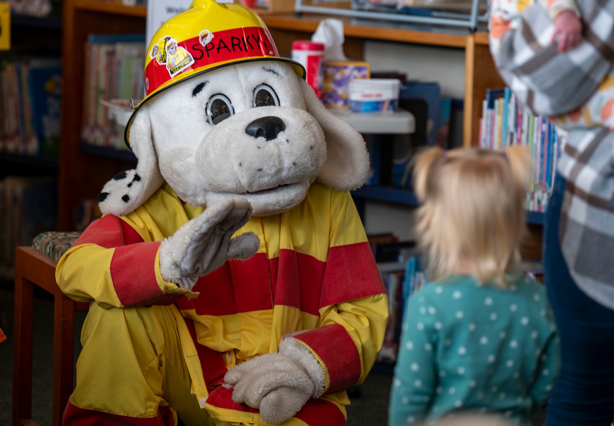 Sparky the fire dog, the mascot for the National Fire Protection Association, waves to a child.