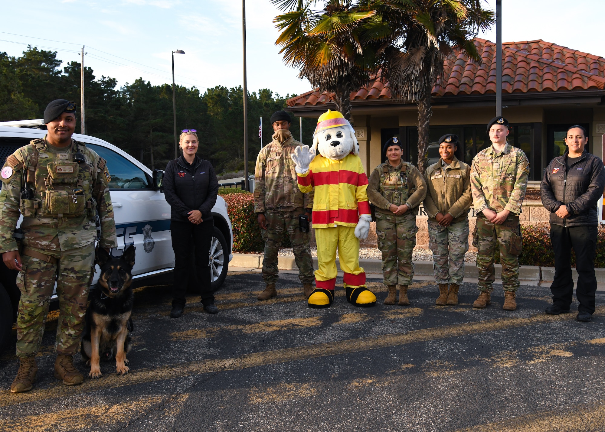 Members the 30th Civil Engineer Squadron fire department and 30th Security Forces Squadron, pose for a photo with Sparky the Firedog, center, at Vandenberg Space Force Base, Calif., Oct. 13, 2023.