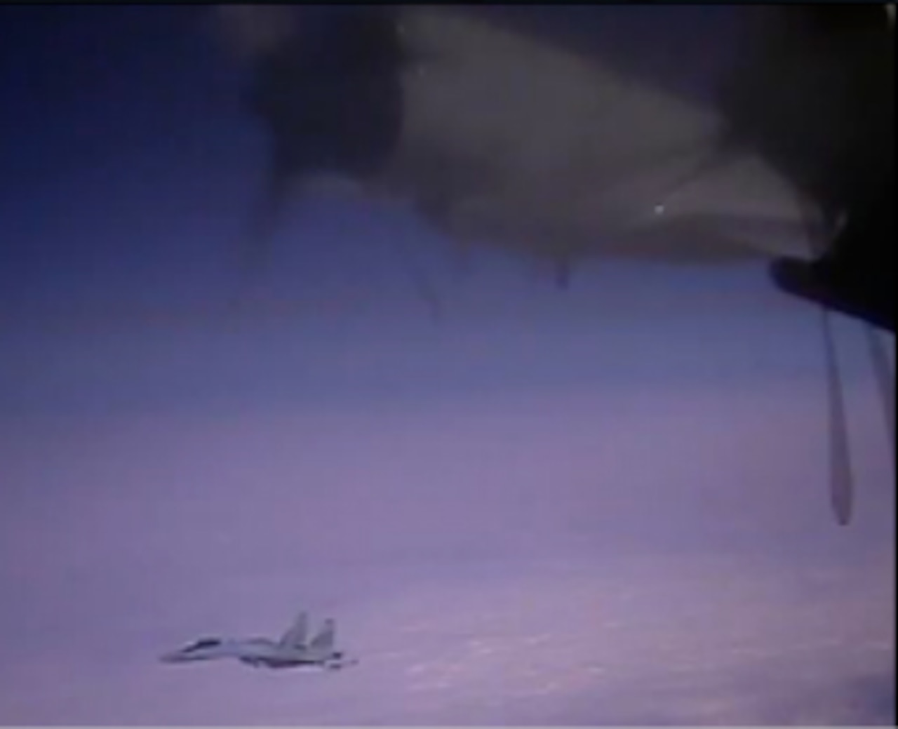 A jet flies near another, partly visible in foreground.
