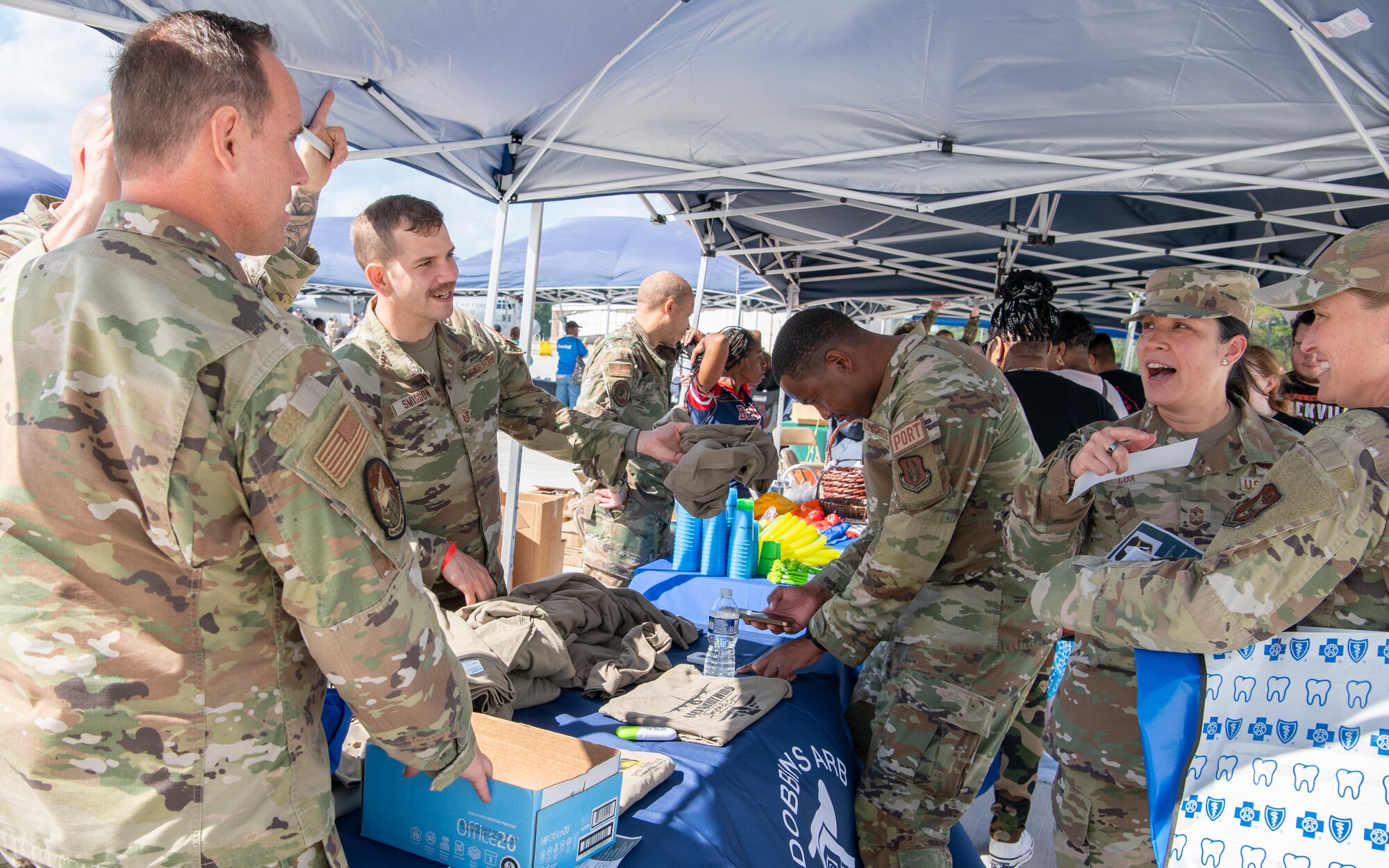 people in military uniforms talk and laugh with each other