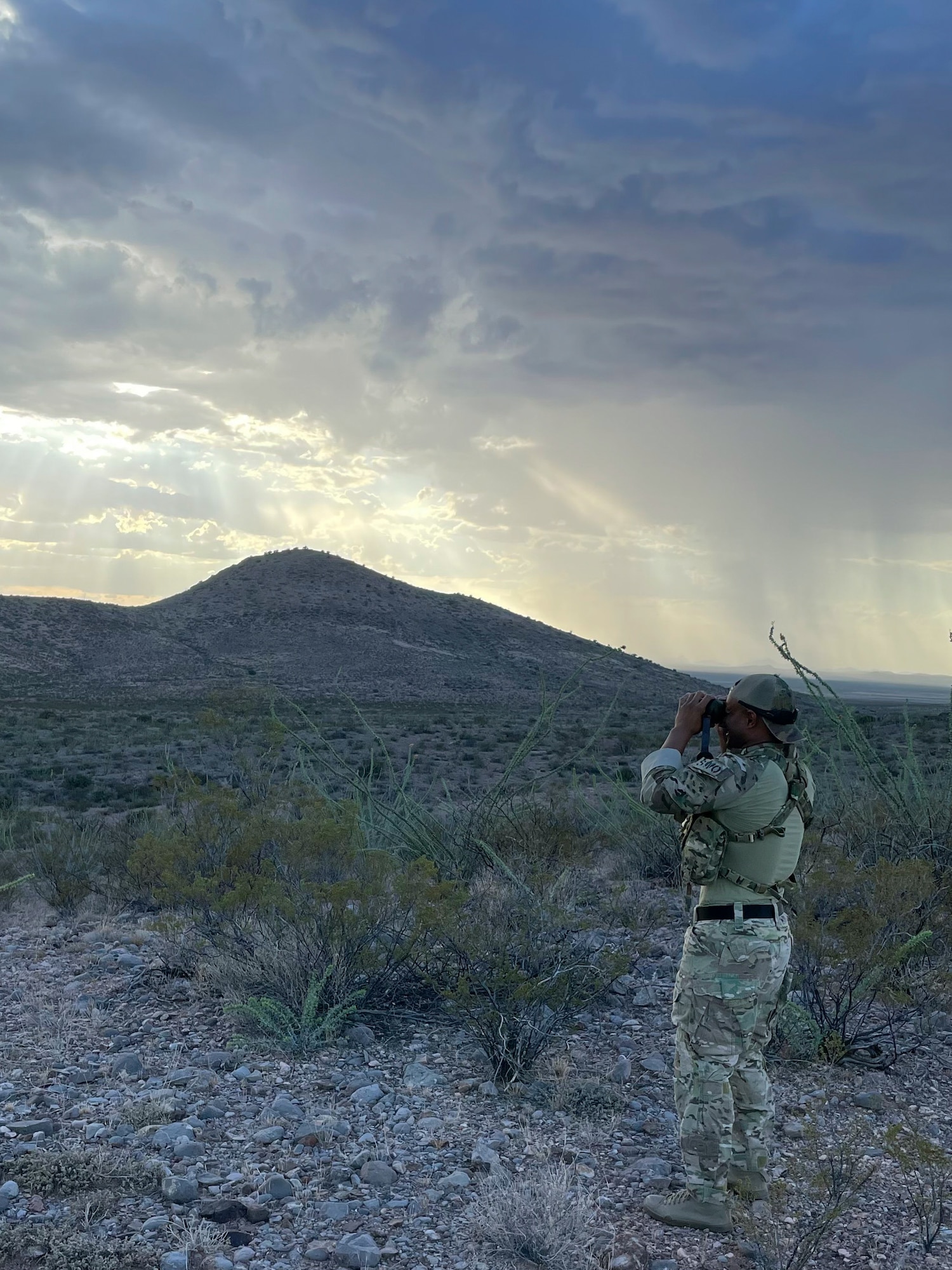 An Airman looks through binoculars