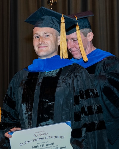 Capt. Stephen Donnel receives his doctoral hood from his faculty advisor, Dr. Brian Lunday,