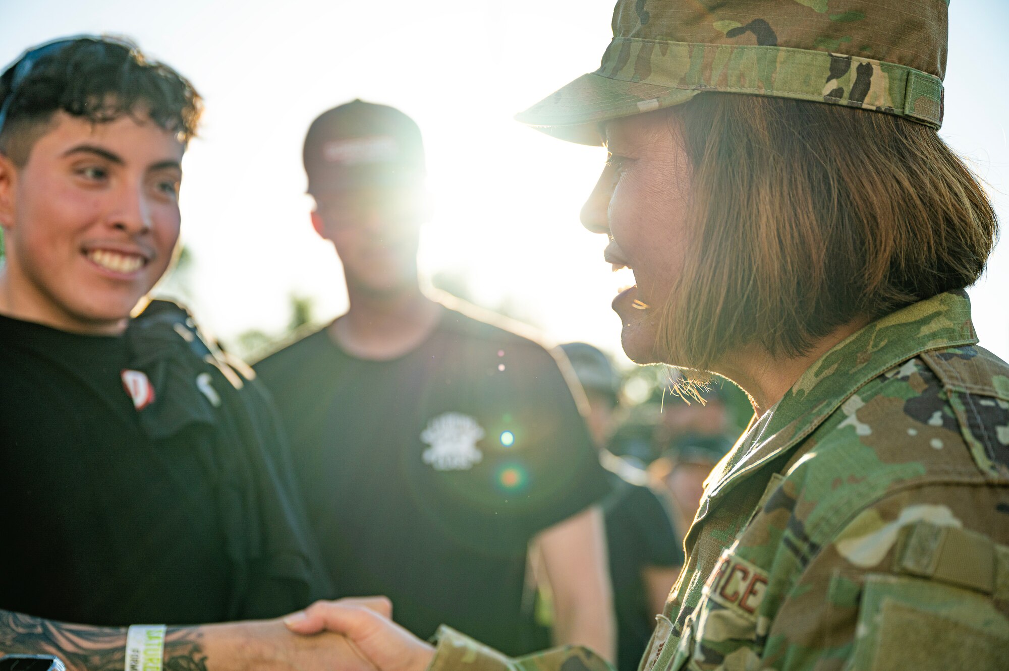 woman in uniform shakes the hand of a young man