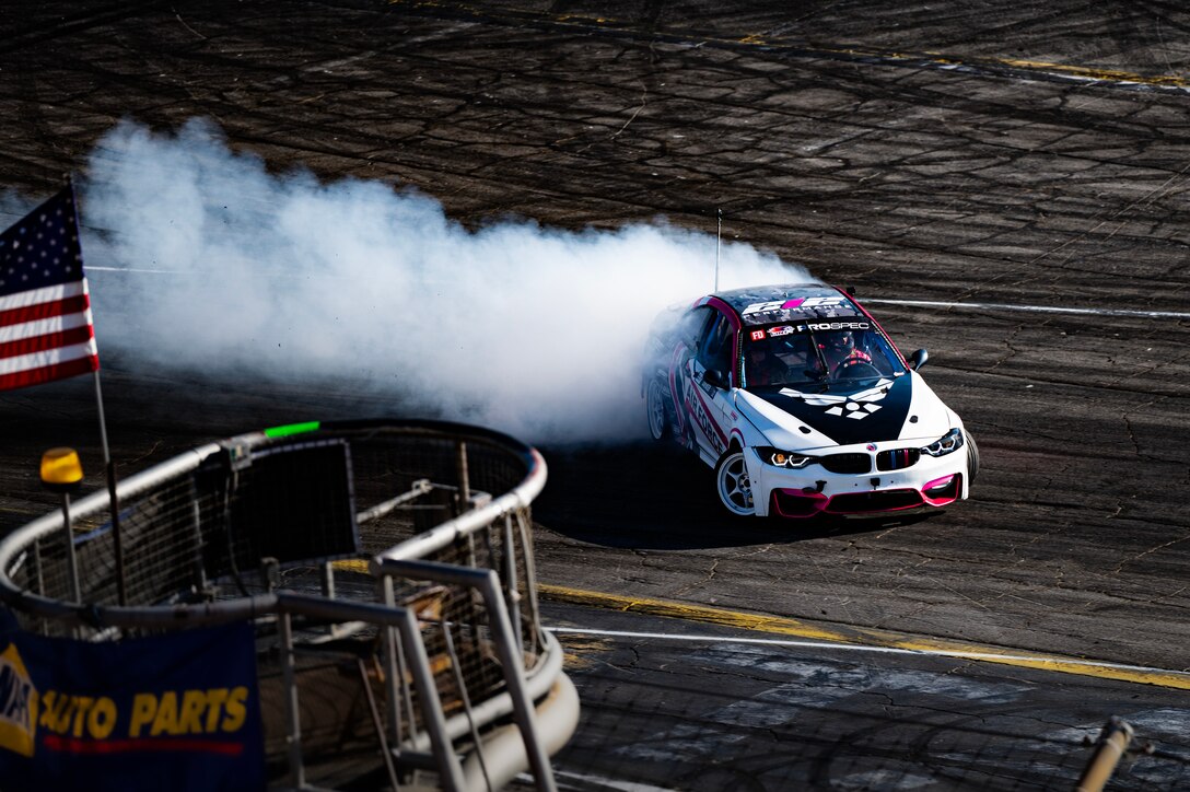 race car kicks up smoke as it makes the sharp turn