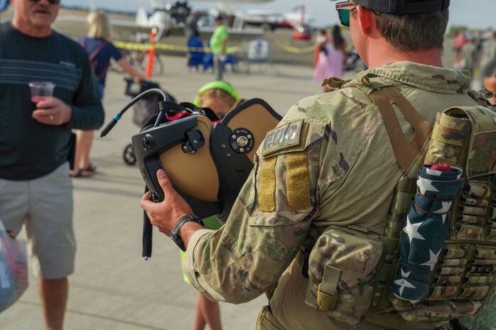U.S. Air Force Staff Sgt. Connor Ely, Explosive Ordnance Disposal (EOD) technician, 9th Civil Engineer Squadron, explains the components of an EOD 10 suit helmet to community members at the Chico Regional Airport Open House Chico, California on Oct. 14, 2023.