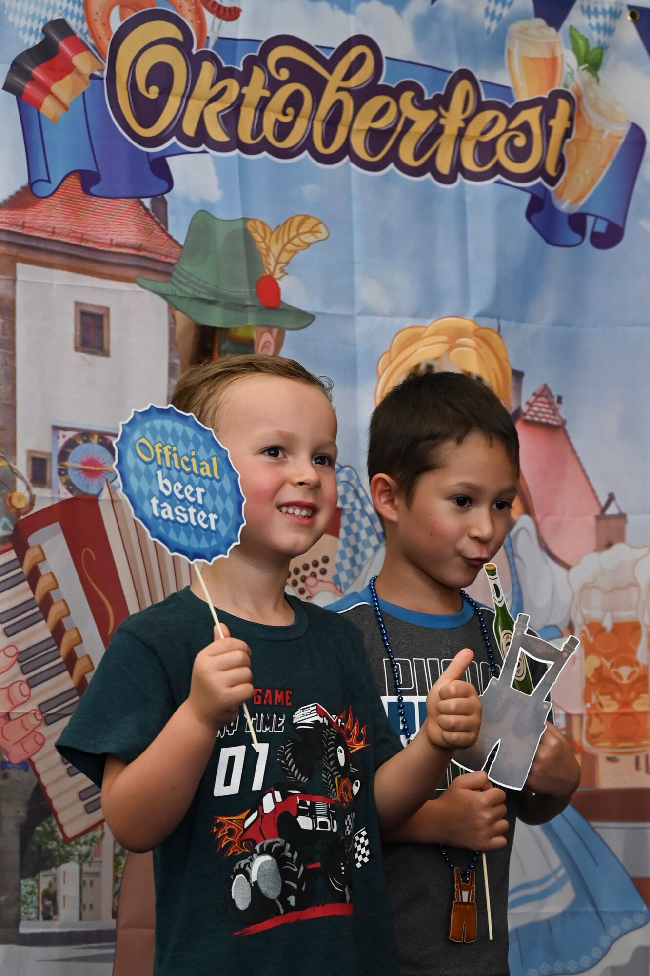 Two Team Andersen kids pose for photos at a photo booth during the 36th Wing First Friday Oktoberfest event at Andersen Air Force Base, Guam, Oct. 6, 2023.