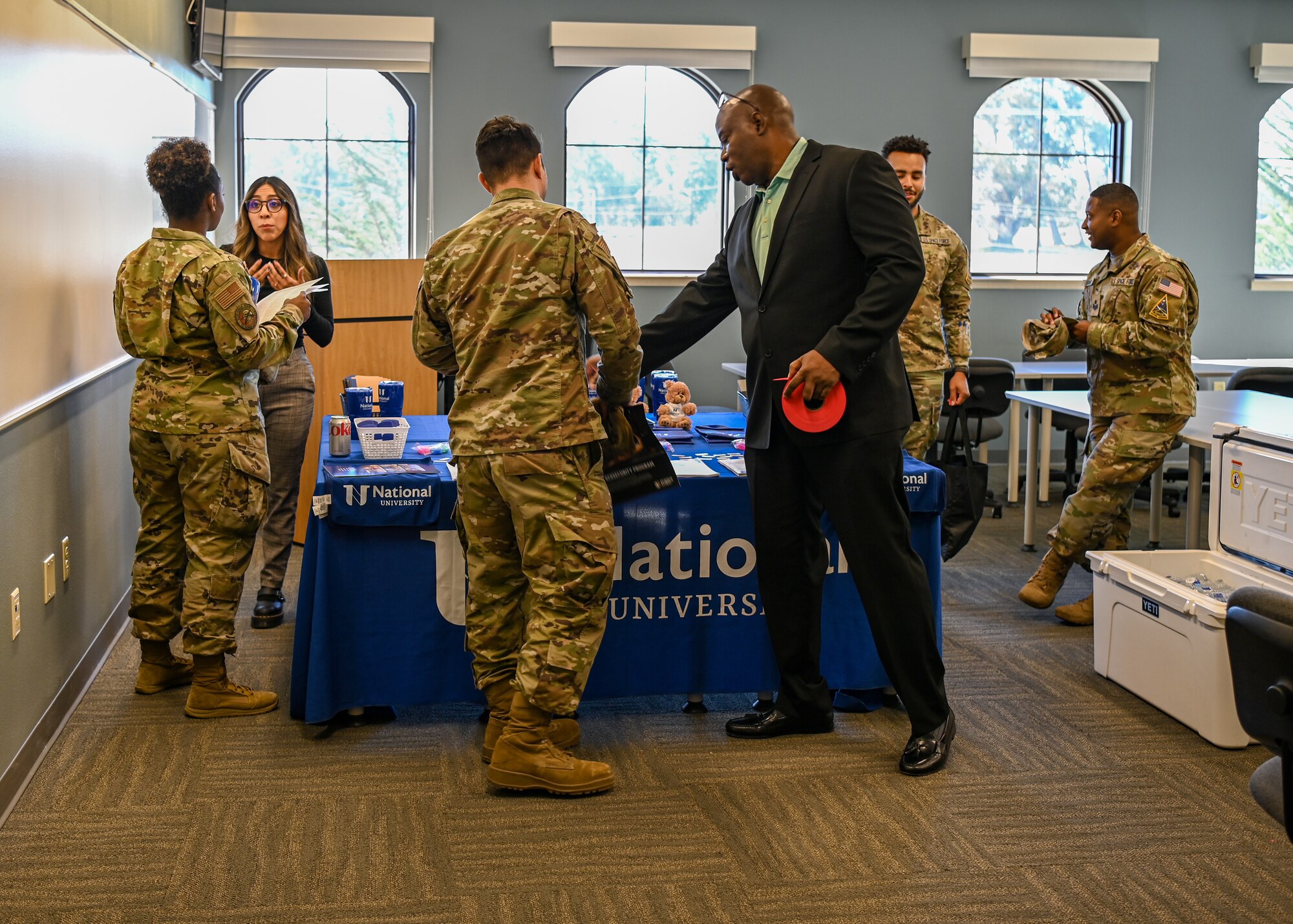 A college representative speaks with guests on how to apply for college classes during an education center open house.