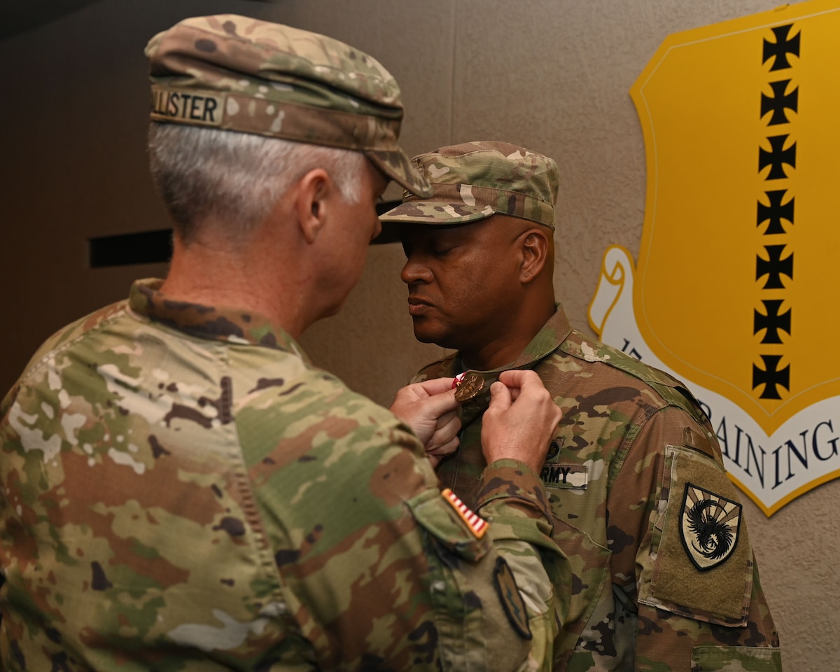 U.S. Army Lt. Col John McAllister, 344th Military Intelligence Battalion commander, pins the Meritorious Service Medal on Sgt. Maj. Sudan Baker, outgoing 344th MI BN command sergeant major, during the 344th MI BN assumption of responsibility ceremony at the parade field pavilion, Goodfellow Air Force Base, Texas, Oct. 11, 2023. While serving as the command sergeant major of the 344th MI BN, Baker's leadership, mission focus and care for the organization led to him receiving the medal. (U.S. Air Force photo by Airman 1st Class Evelyn J. D’Errico)