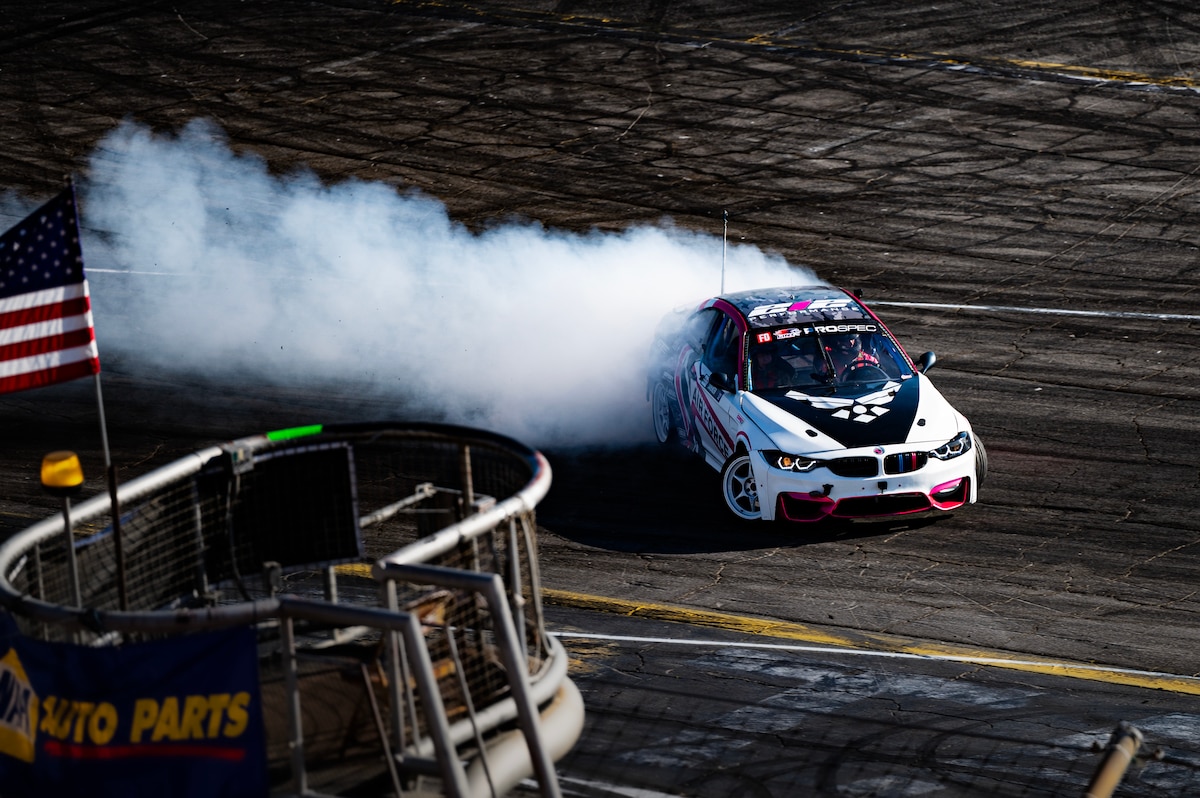 race car kicks up smoke as it makes the sharp turn