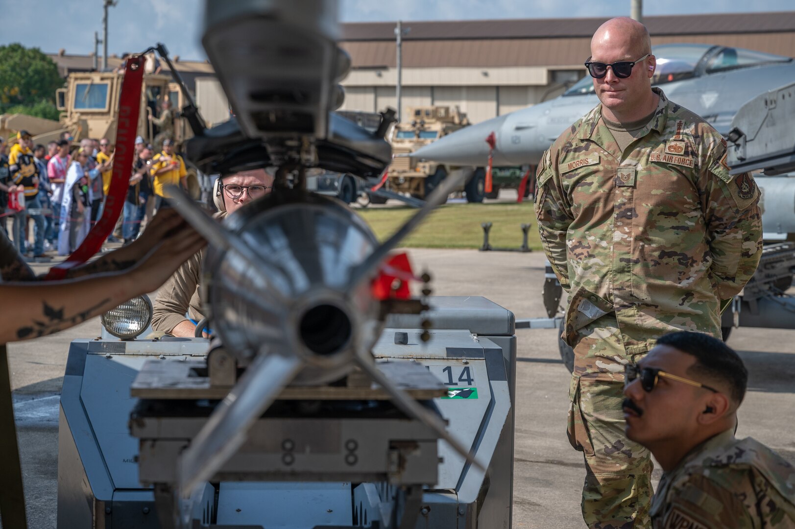 A weapons load crew member, coordinates the position of a munition with his team members during Pen Fest, the annual bilateral munitions load crew competition, at Kunsan Air Base