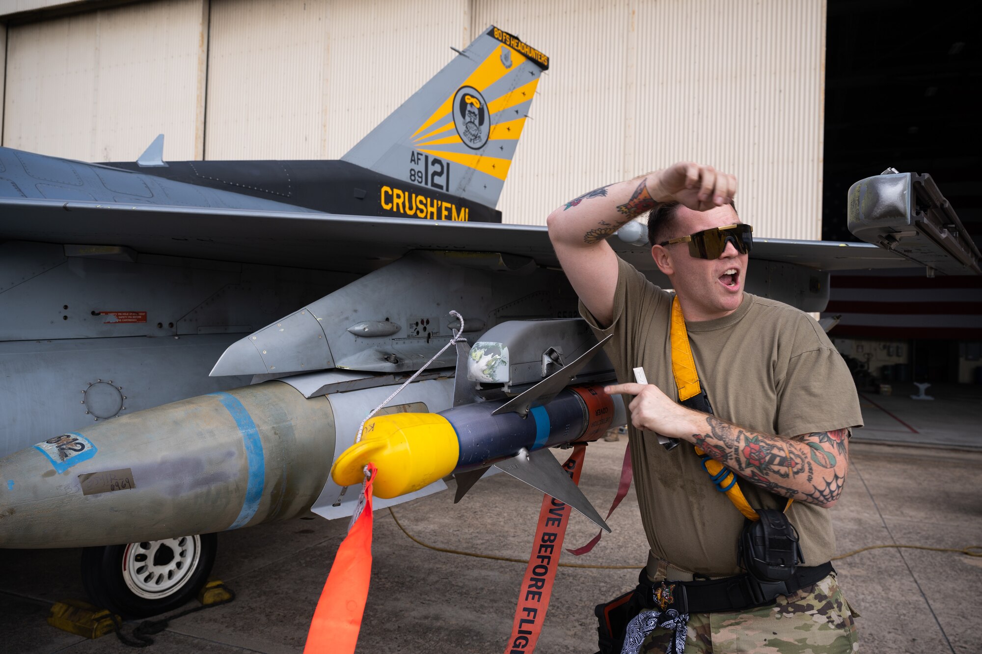 A load crew member, shouts the status of the loaded munition during Pen Fest, the annual bilateral munitions load crew competition at Kunsan Air Base