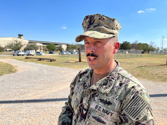 A Seabee is talking outdoors