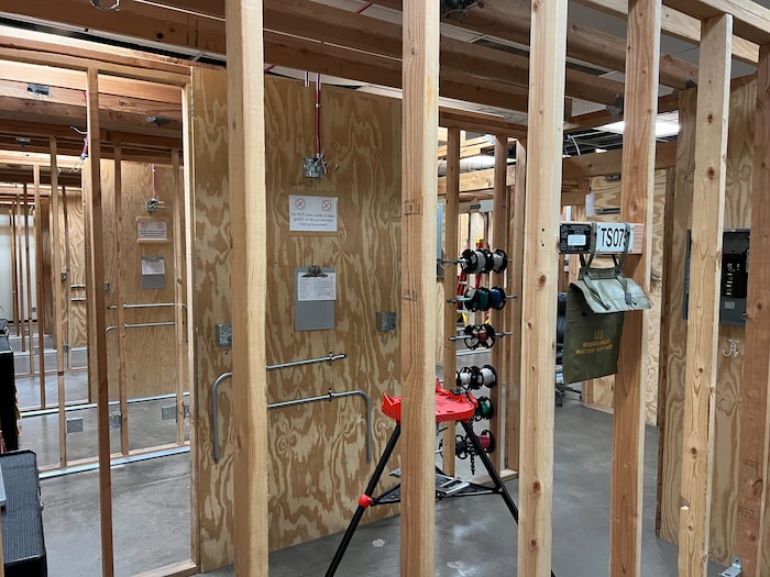 A series of rooms framed with 2x4 beams and no walls. There are electrical wires and outlets visible.