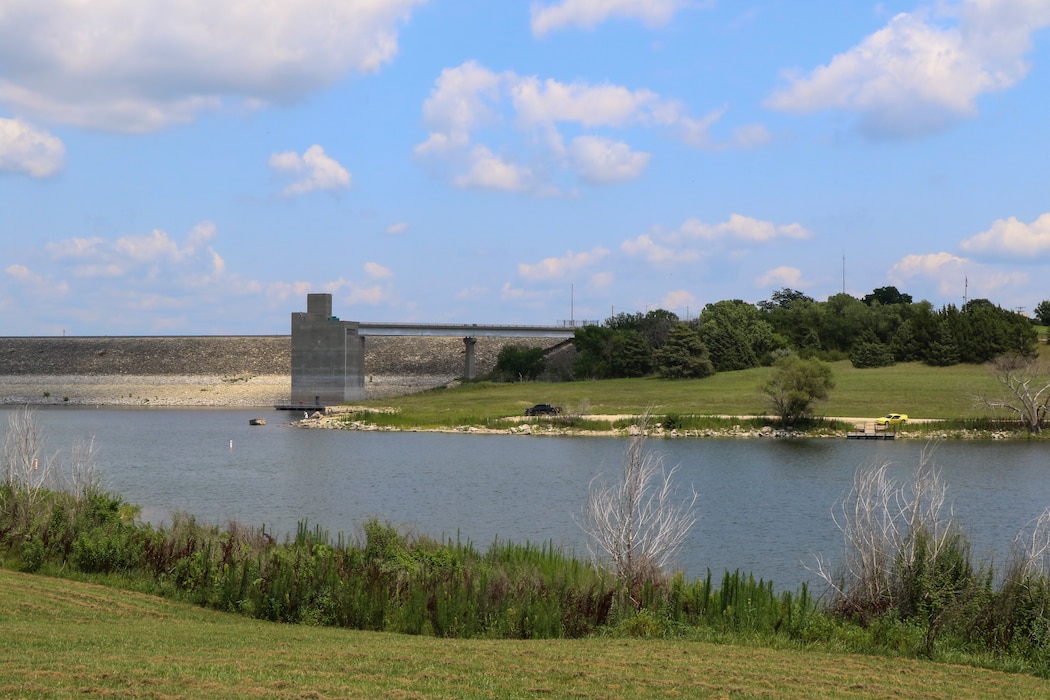 A lake can be seen with grass in the foreground and background.