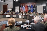 A group of Defense Logistics Agency and Navy leaders sit around a table in a conference room.
