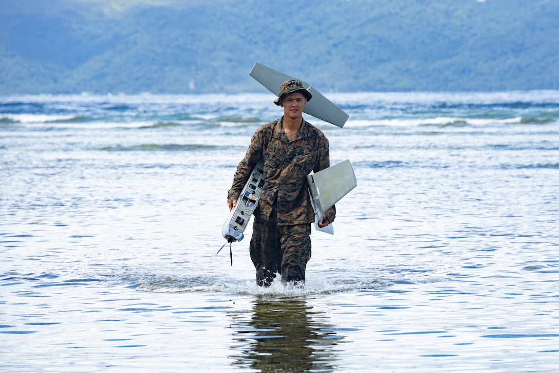 U.S. Marine Corps Sgt. Vincent Tran, a maritime sensing chief, with Marine Rotational Force-Southeast Asia, I Marine Expeditionary Force, retrieves a RQ-20 PUMA, a small, unmanned aircraft system after a planned water landing at a shore-based maritime sensing site for a simulated close air support activity during MRF-SEA 23 in Sorsogon, Luzon, Philippines, Oct. 11, 2023. Maritime sensing sites improve the maritime domain awareness picture and improve lethality of the joint force. MRF-SEA is a Marine Corps Forces Pacific operational model which involves planned exchanges with subject matter experts, promotes security goals with Allies and partners, and positions I MEF forces west of the International Date Line. (U.S. Marine Corps photo by Staff Sgt. Kai W. Huber)