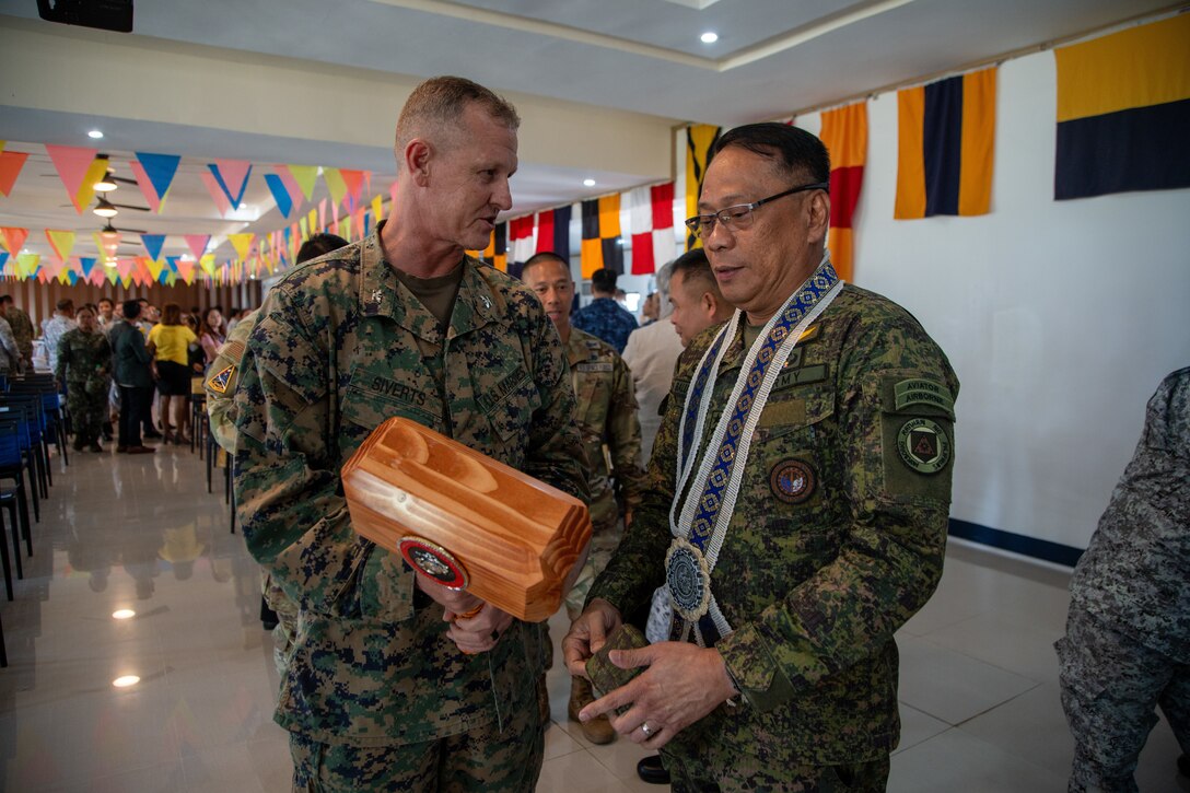 U.S. Marine Corps Col. Thomas M. Siverts, commanding officer of Marine Rotational Force-Southeast Asia, I Marine Expeditionary Force, gives a gift to Philippine Army Lt. Gen. Efren P. Baluyot, commander of Southern Luzon Command, during the Maritime Training Activity Sama Sama 2023 closing ceremony on Naval Station Julhasan Arasain in Legazpi, Luzon, Philippines, Oct. 13, 2023. MTA Sama Sama is a multinational exercise including forces from the Philippines, United States, Australia, France, Japan, Canada, and the United Kingdom designed to promote regional security cooperation, enhance maritime interoperability, and maintain and strengthen maritime partnerships. MRF-SEA is a Marine Corps Forces Pacific operational model which involves planned exchanges with subject matter experts, promotes security goals with Allies and partners, and positions I MEF forces west of the International Date Line. (U.S. Marine Corps photo by Sgt. Ryan H. Pulliam)