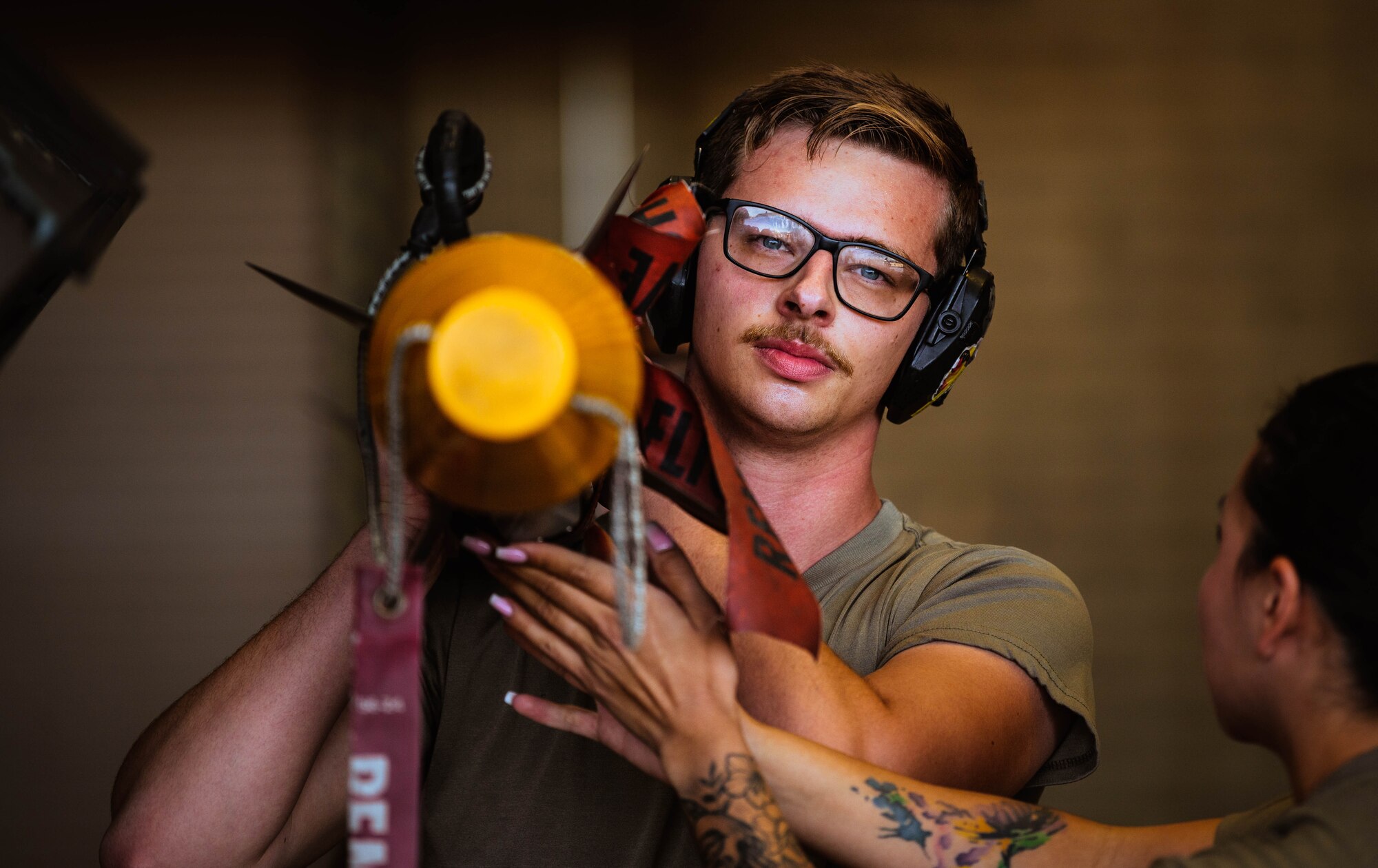 U.S. Air Force Senior Airman Christopher Gitch, 310th Aircraft Maintenance Unit weapons load crew member, helps prepare a GBU-12 Paveway II bomb for a U.S. Air Force F-35A Lightning II during the third quarterly weapons load competition.