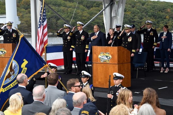 Members of the official party for USS Hyman G. Rickover (SSN 795) salute the ensign during a commissioning ceremony at Naval Submarine Base New London in Groton, Connecticut on October 14, 2023.