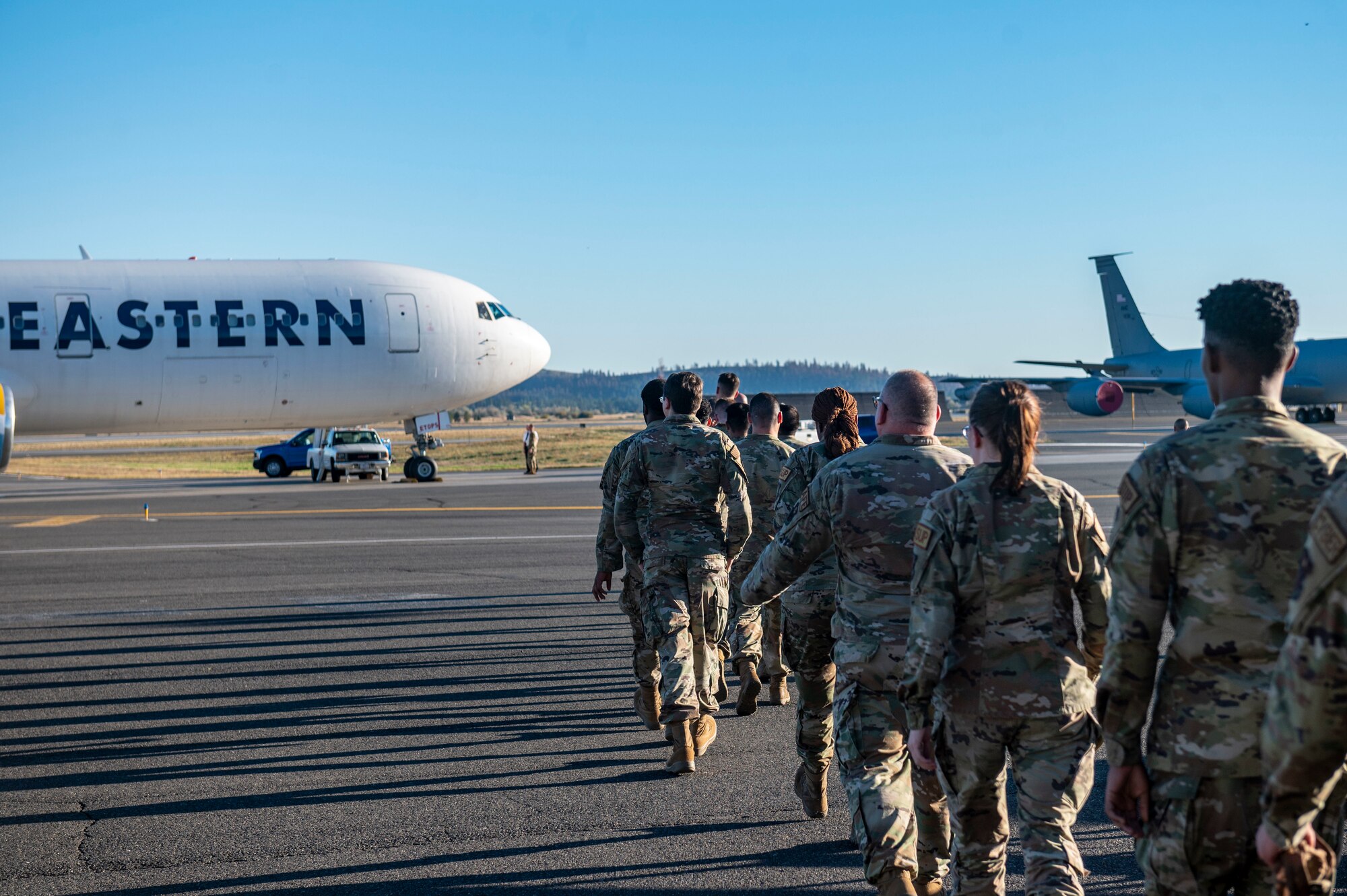 Airmen walk to board a plane.
