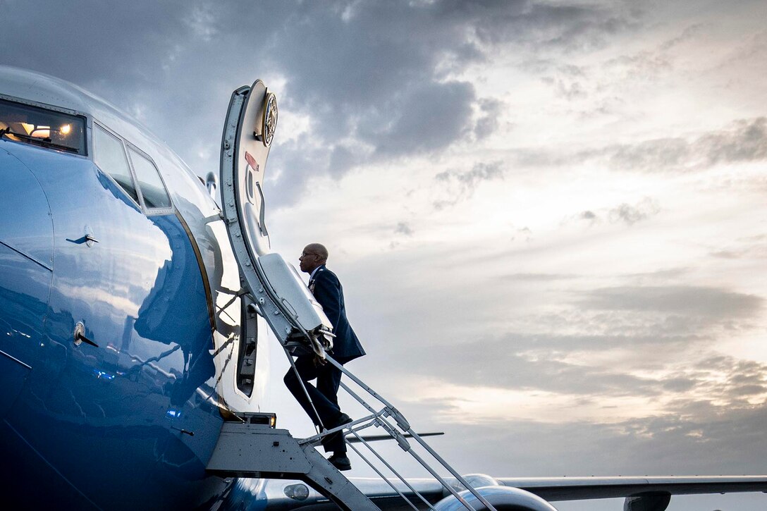 Air Force Gen. CQ Brown, Jr. ascends steps to board an aircraft.