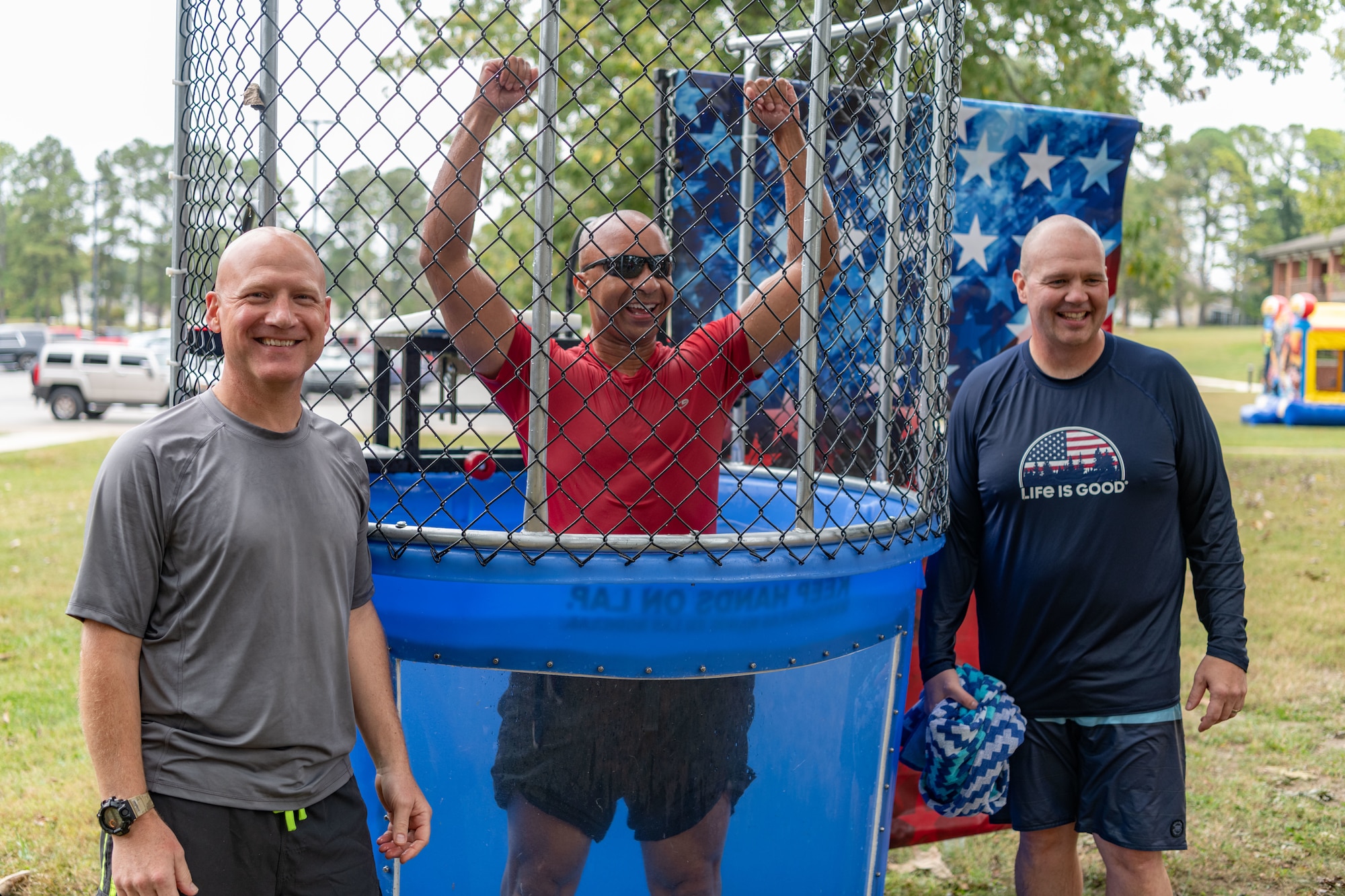 Arnold Engineering Development Complex Test Support Division Chief Col. Eric Withrow, left, AEDC Commander Col. Randel Gordon, center, and AEDC 804th Test Group Commander Col. Jason Vap, pose for a photo after taking turns in the dunk tank during the Arnold Air Force Base Sports Day event, Oct. 5, 2023, at the Arnold Lakeside Complex at Arnold AFB, Tenn. Along with dunk tank, events included running, pickleball, cornhole, volleyball, axe throwing, tug of war and disc golf. (U.S. Air Force photo by Keith Thornburgh)