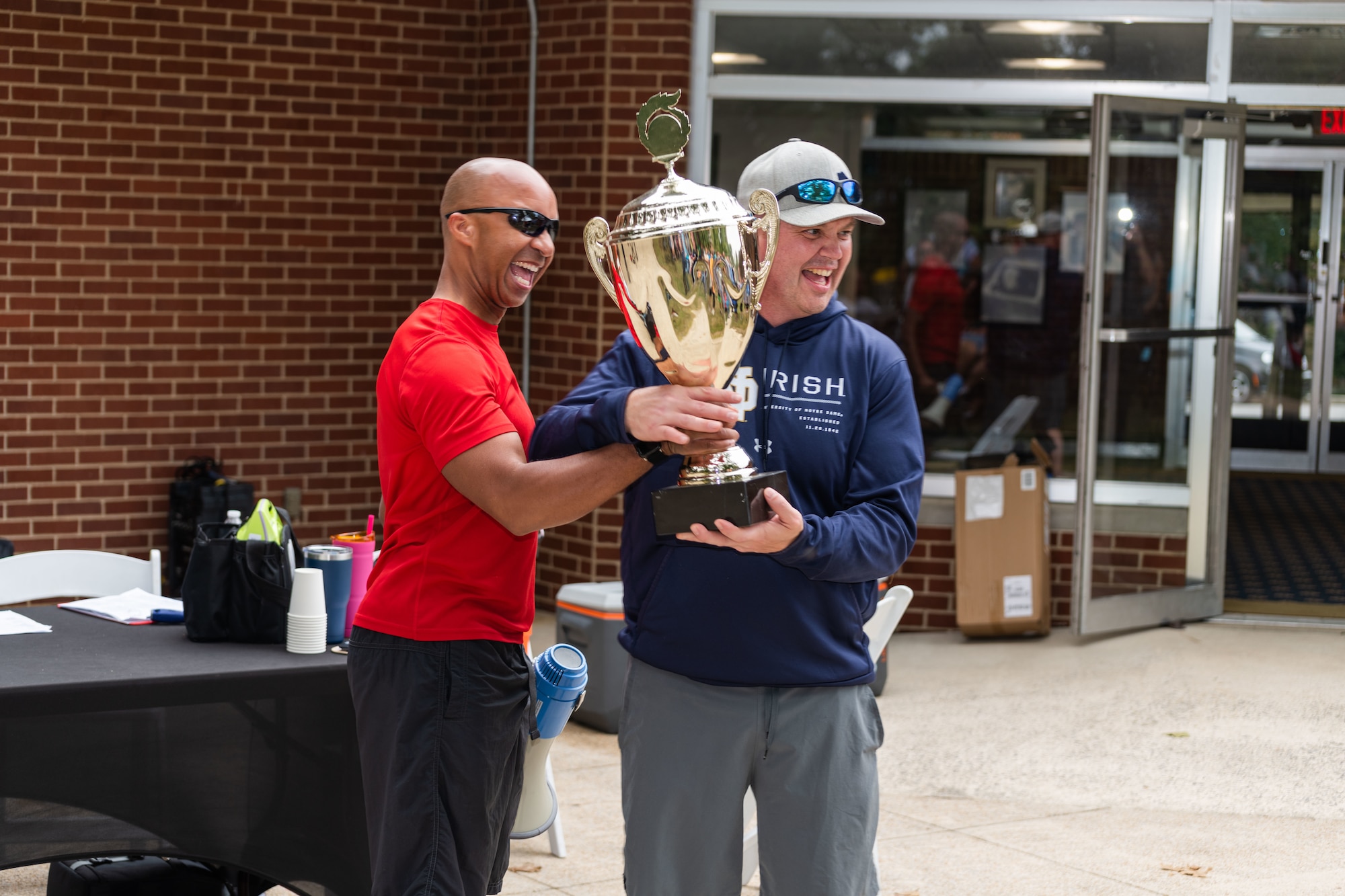 Arnold Engineering Development Complex Commander Col. Randel Gordon, left, hands the Arnold Air Force Base Sports Day trophy to Col. Jason Vap, commander of the AEDC 804th Test Group. The 804TG was the winner of the Sports Day event, held Oct. 5, 2023, at the Arnold Lakeside Complex at Arnold AFB, Tenn. Events included running, pickleball, cornhole, volleyball, axe throwing, tug of war, a dunk tank and disc golf. (U.S. Air Force photo by Keith Thornburgh)