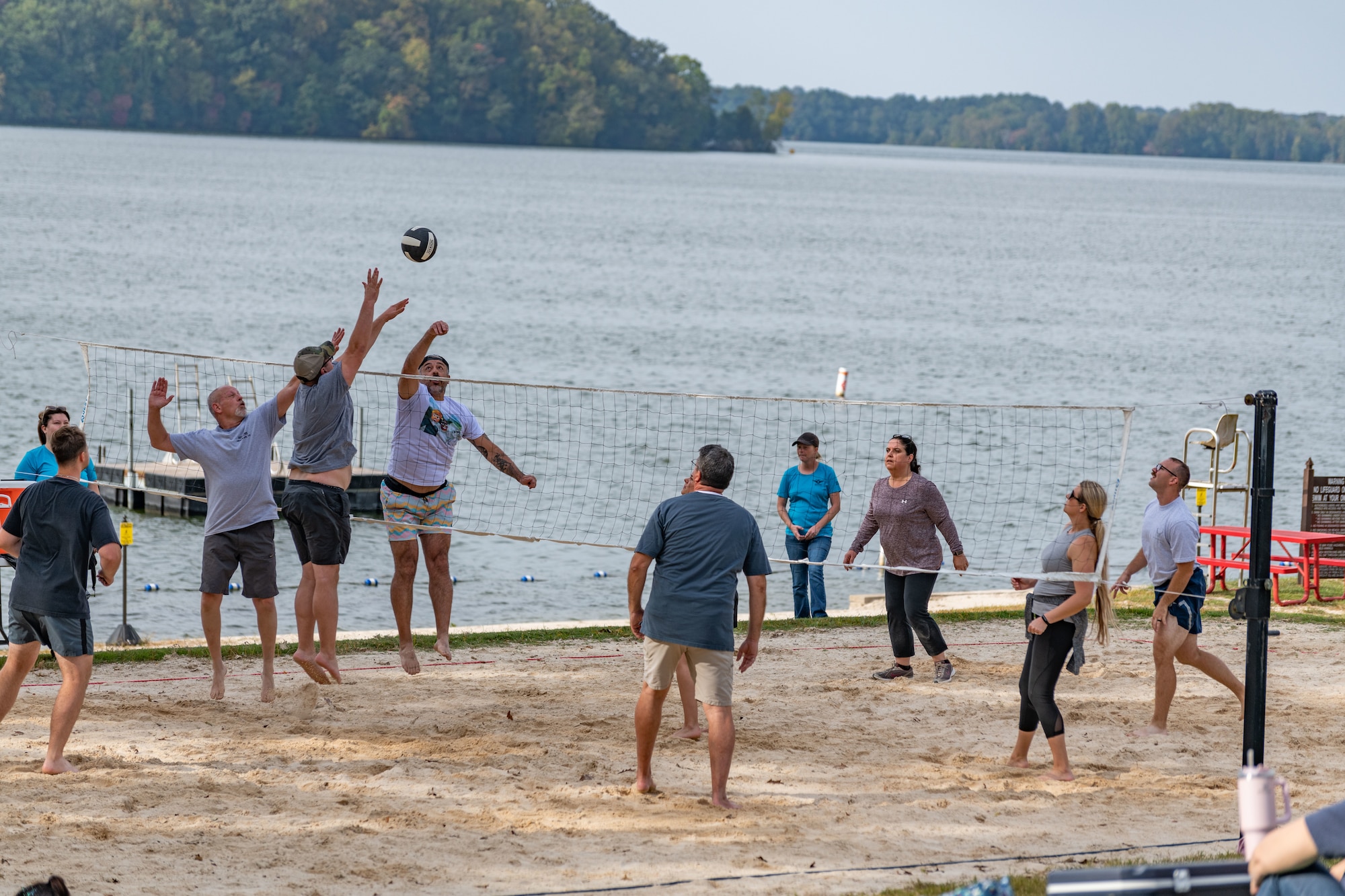 Base team members play volleyball during the Arnold Air Force Base Sports Day event, Oct. 5, 2023, at the Arnold Lakeside Complex at Arnold AFB, Tenn. Along with volleyball, events included running, pickleball, cornhole, disc golf, axe throwing, tug of war and a dunk tank. (U.S. Air Force photo by Keith Thornburgh)