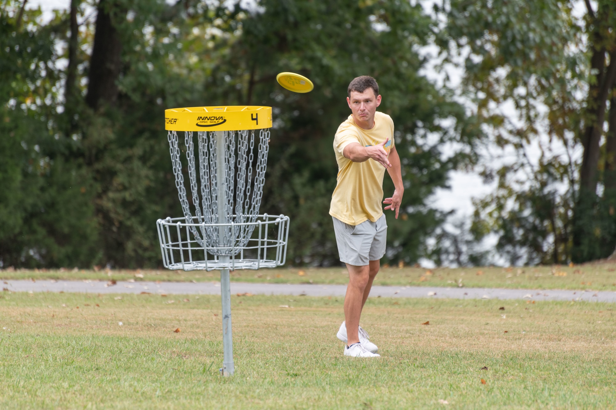 A base team member putts for the basket while participating in the disc golf portion of the Arnold Air Force Base Sports Day event, Oct. 5, 2023, at the Arnold Lakeside Complex at Arnold AFB, Tenn. Along with disc golf, events included running, pickleball, cornhole, volleyball, axe throwing, tug of war and a dunk tank. (U.S. Air Force photo by Keith Thornburgh)
