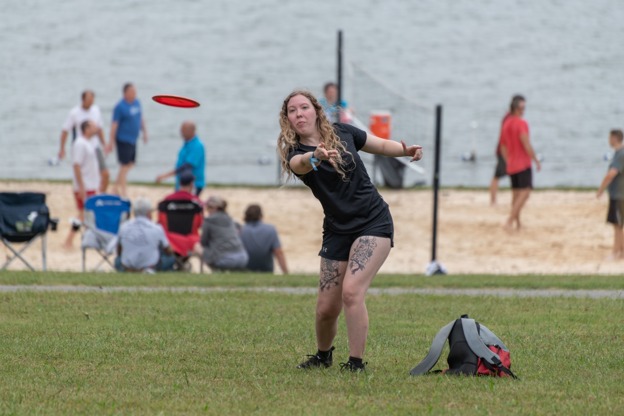 A base team member shoots for the basket while participating in the disc golf portion of the Arnold Air Force Base Sports Day event, Oct. 5, 2023, at the Arnold Lakeside Complex at Arnold AFB, Tenn. Along with disc golf, events included running, pickleball, cornhole, volleyball, axe throwing, tug of war and a dunk tank. (U.S. Air Force photo by Keith Thornburgh)