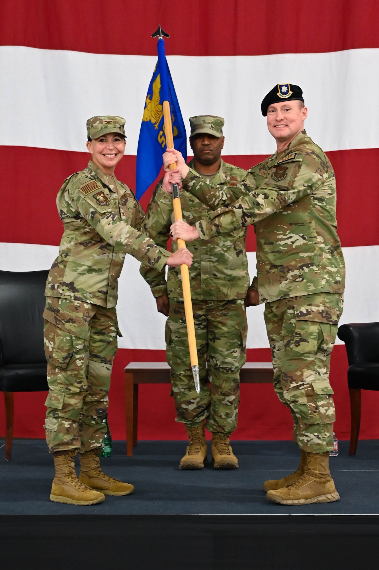 two people holding a flag and smiling at the camera