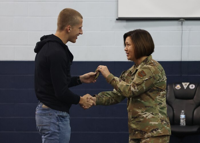 Bass handing student a patch