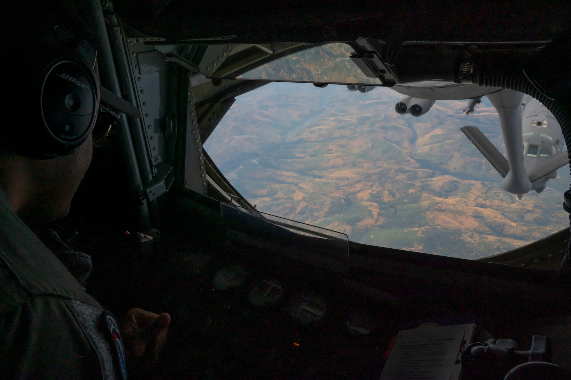 A boom operator prepares to refuel a B 52 Stratofortress.