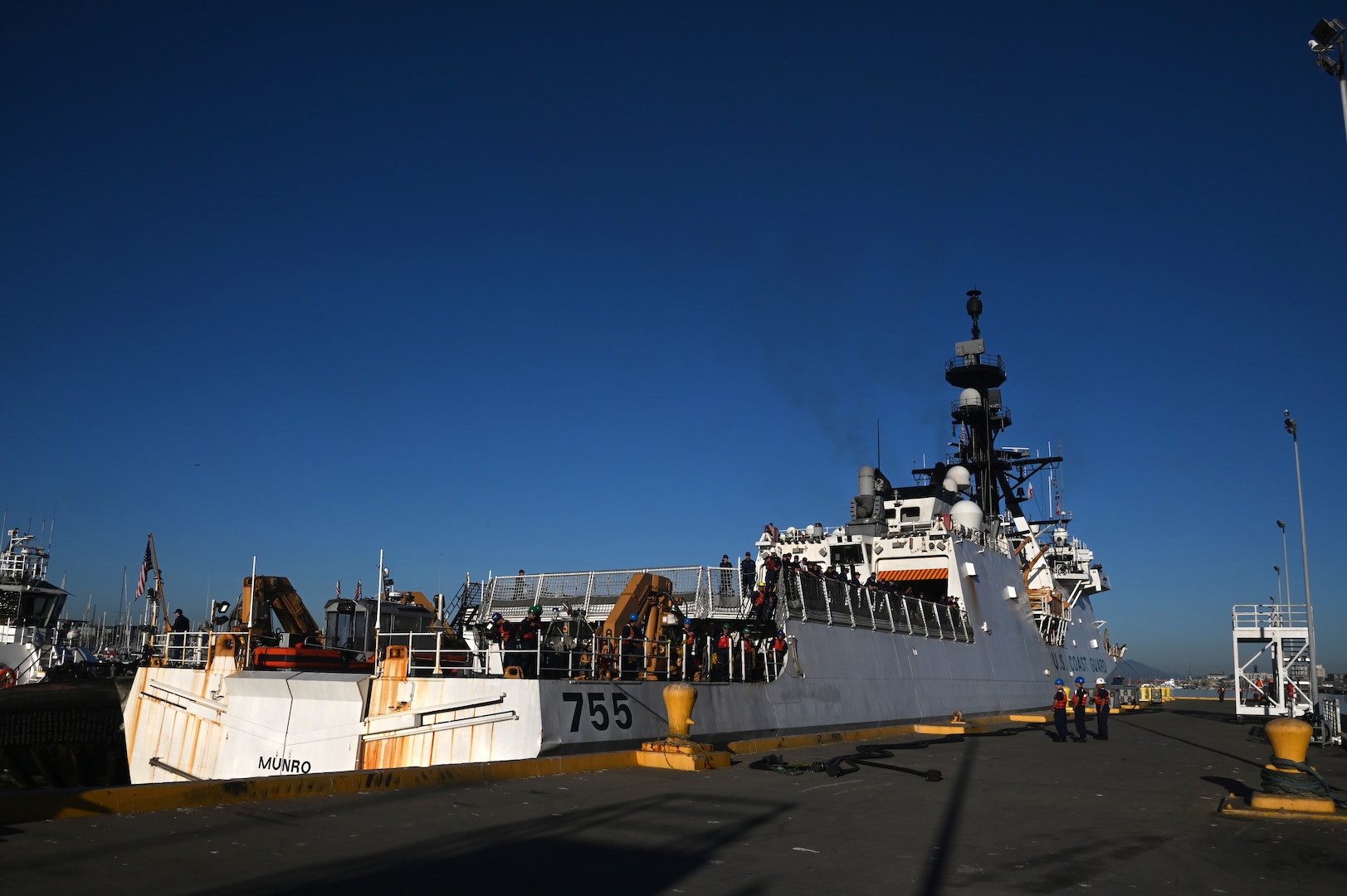 The crew aboard the U.S. Coast Guard Cutter Munro (WMSL 755) prepare to moor to the Base Alameda, California, pier after returning home from a 118-day Western Pacific deployment, Oct. 18. 2023. Munro's crew conducted a 23,000-mile, multi-month Western Pacific patrol operating in support of the U.S. Navy's Seventh Fleet by conducting multiple engagements with partner nations promoting a free and open Indo-Pacific. U.S. Coast Guard photo by Chief Petty Officer Matthew S. Masaschi.