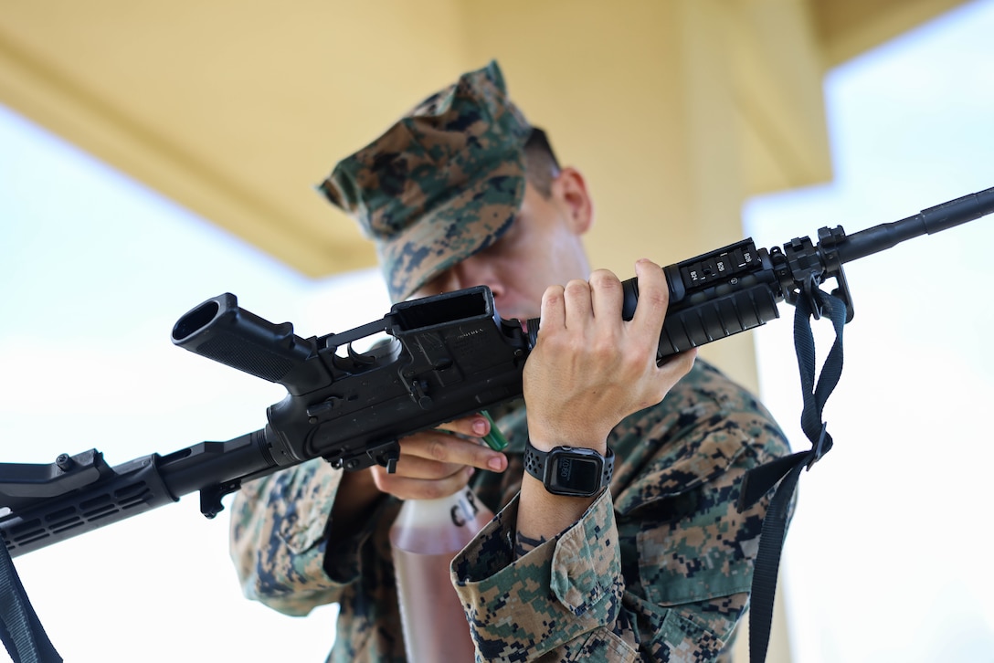 U.S. Marine Corps Cpl. Tylerruben Salas, small arms repair technician for Marine Corps Base Camp Blaz, conducts rifle, pre-fire inspections before shooting on Marine Corps Base Camp Blaz, Guam, Sept. 25, 2023. The Marine Corps’ Program Manager for Training Systems will conduct target calibration from Sept. 25 to Oct. 27 and testing from Dec. 4-15. Two of four ranges at the Live Fire Training Range Complex will be equipped with new technology that provide more efficient and effective combat marksmanship training to support combat readiness. The live-fire location of miss and hit or LOMAH technology, replaces the human element of observing and marking targets. The calibration and testing are to ensure that the LOMAH system is working properly. (U.S. Marine Corps photo by Lance Cpl. Garrett Gillespie)