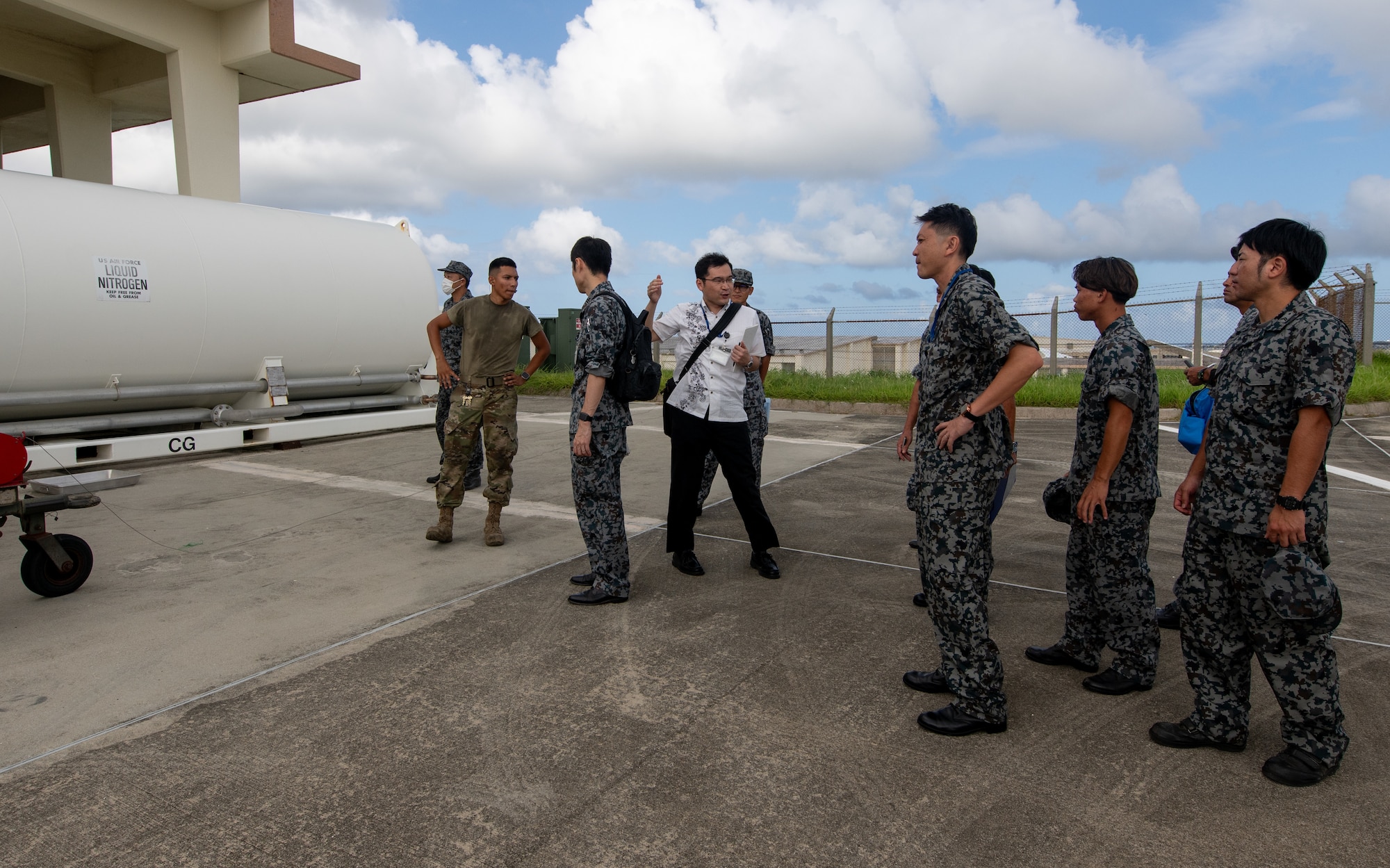 A group of U.S. and Japanese service members discuss cryogenics operations.