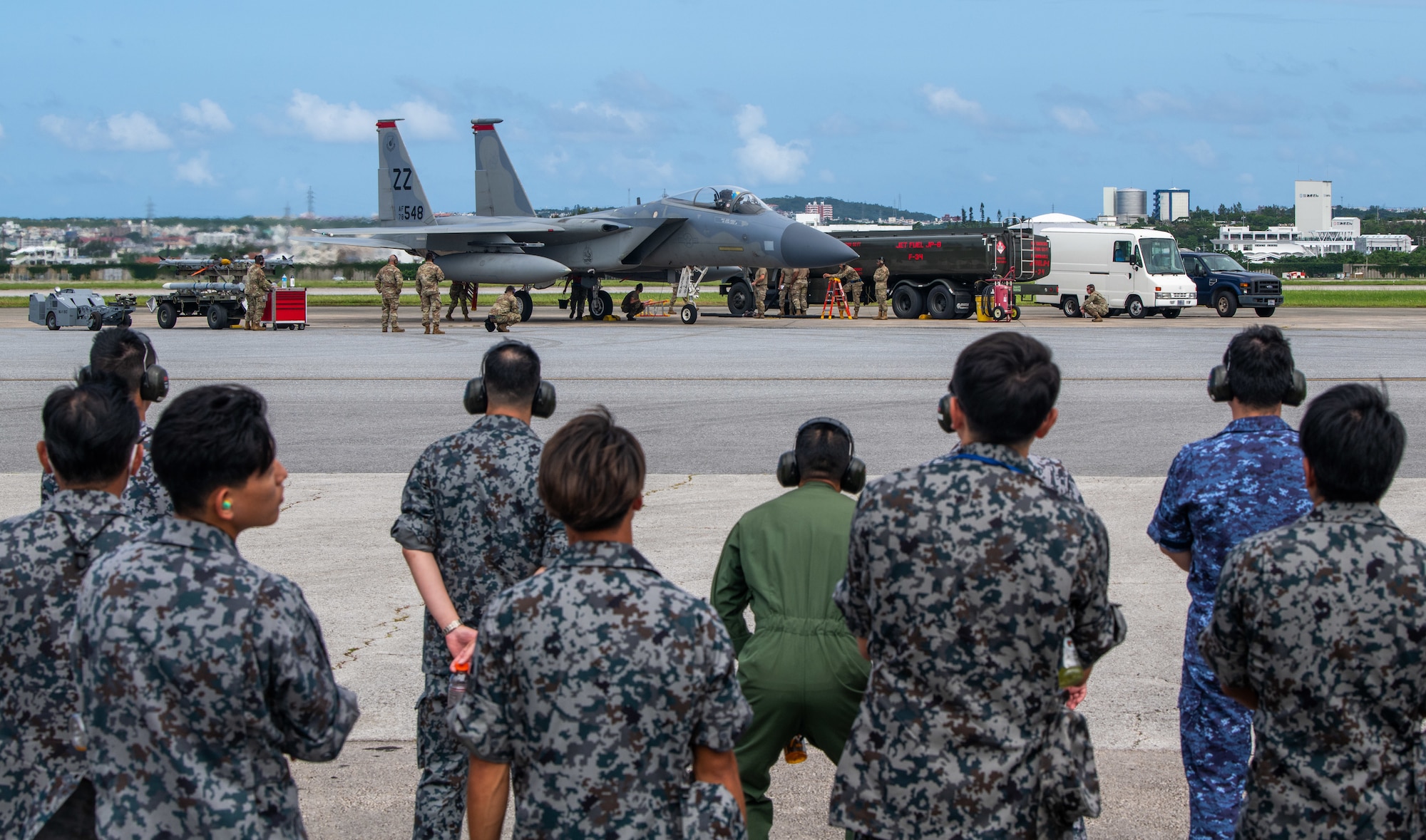 Japanese service members watch an integrated combat turn demonstration.