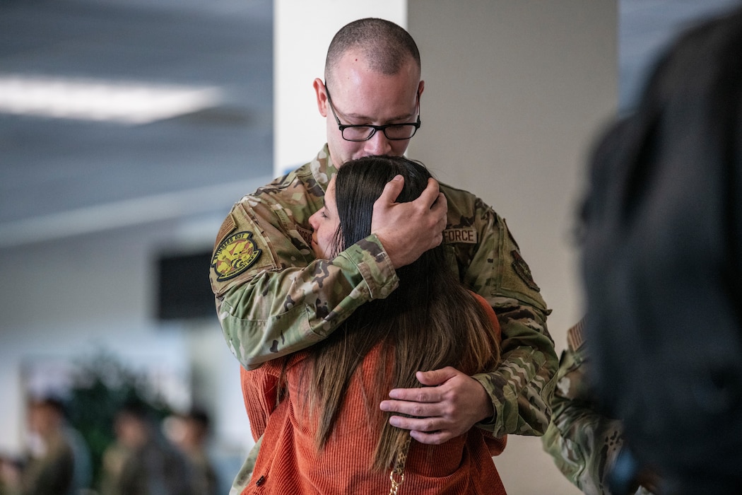 military member hugs a family member